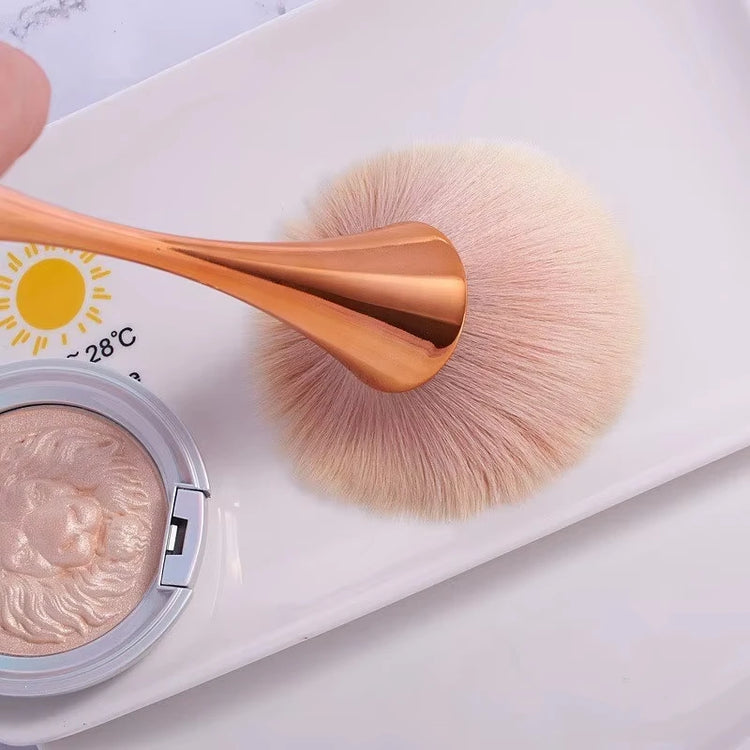 Makeup brush applying highlighter to cheekbone
