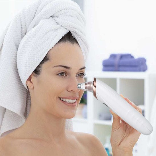 Woman using a blackhead remover vacuum on her nose