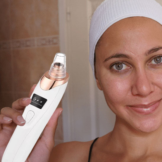Woman using a blackhead remover vacuum on her nose