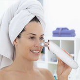 Woman using a blackhead remover vacuum on her nose